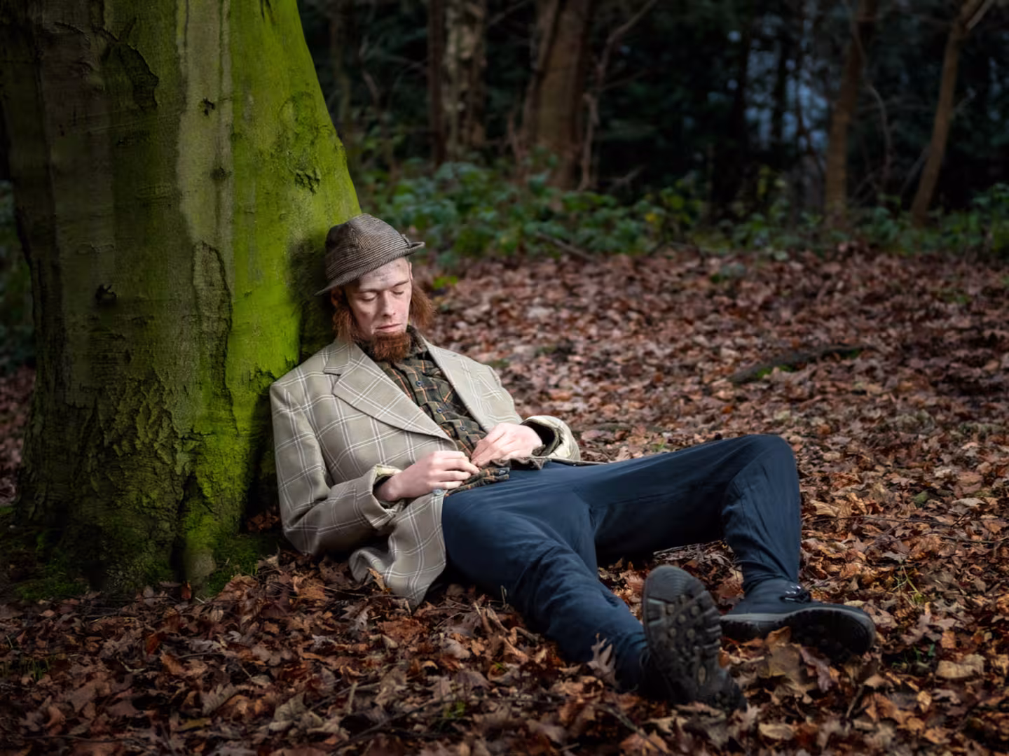 Man laying down against a tree
