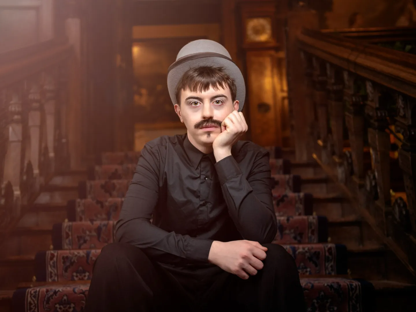 Man sitting on stairs with a top hat