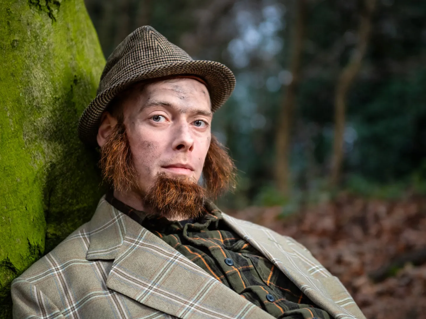 Man laying down against a tree