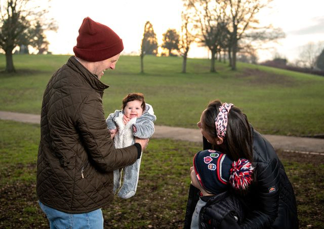 Dad holding baby girl in a park