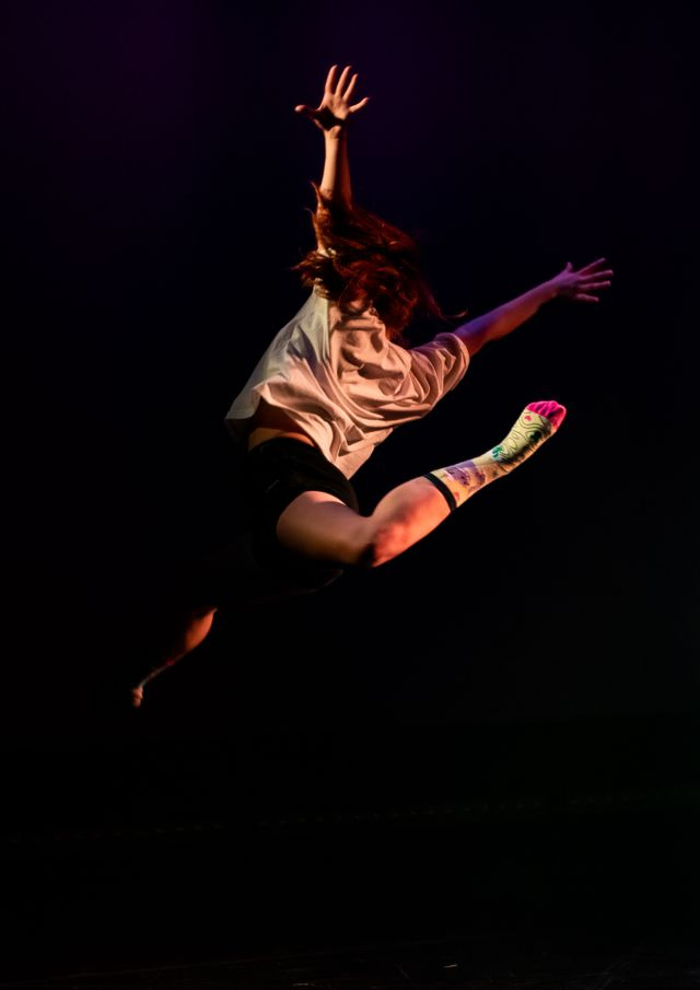 A dancer leaping into the darkness