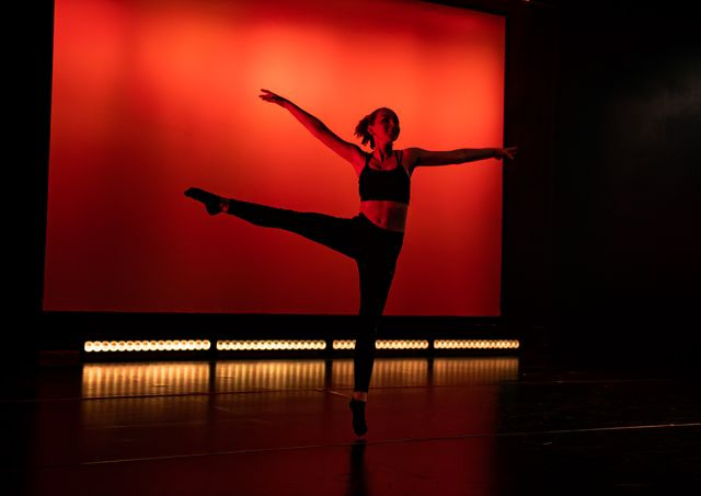 Dancer in red light on stage spining