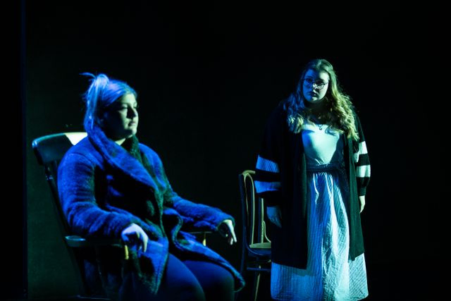 Couple of woman on stage in dark and gloomy setting