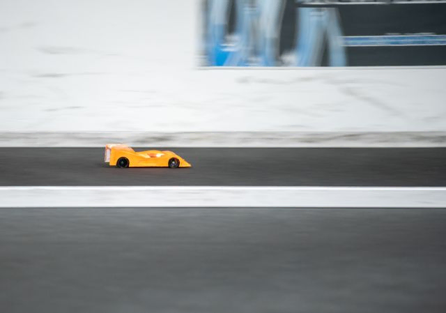 Orange RC car going fast on straight