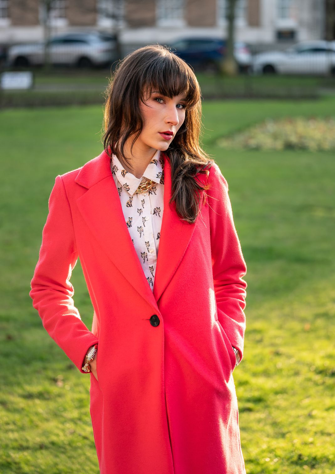 Woman in pink jacket standing in a park