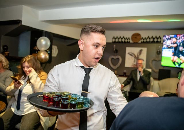 Man holding a tray of shots trying to sell them