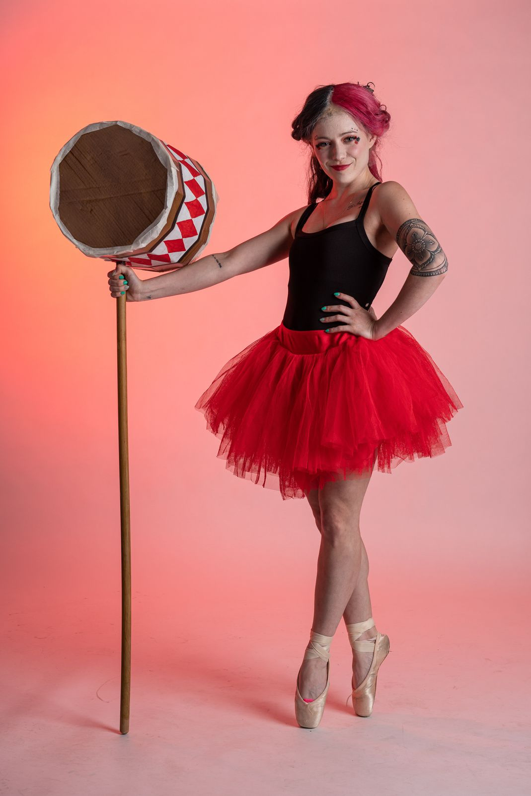 Women wearing a red tutu holding a large hammer