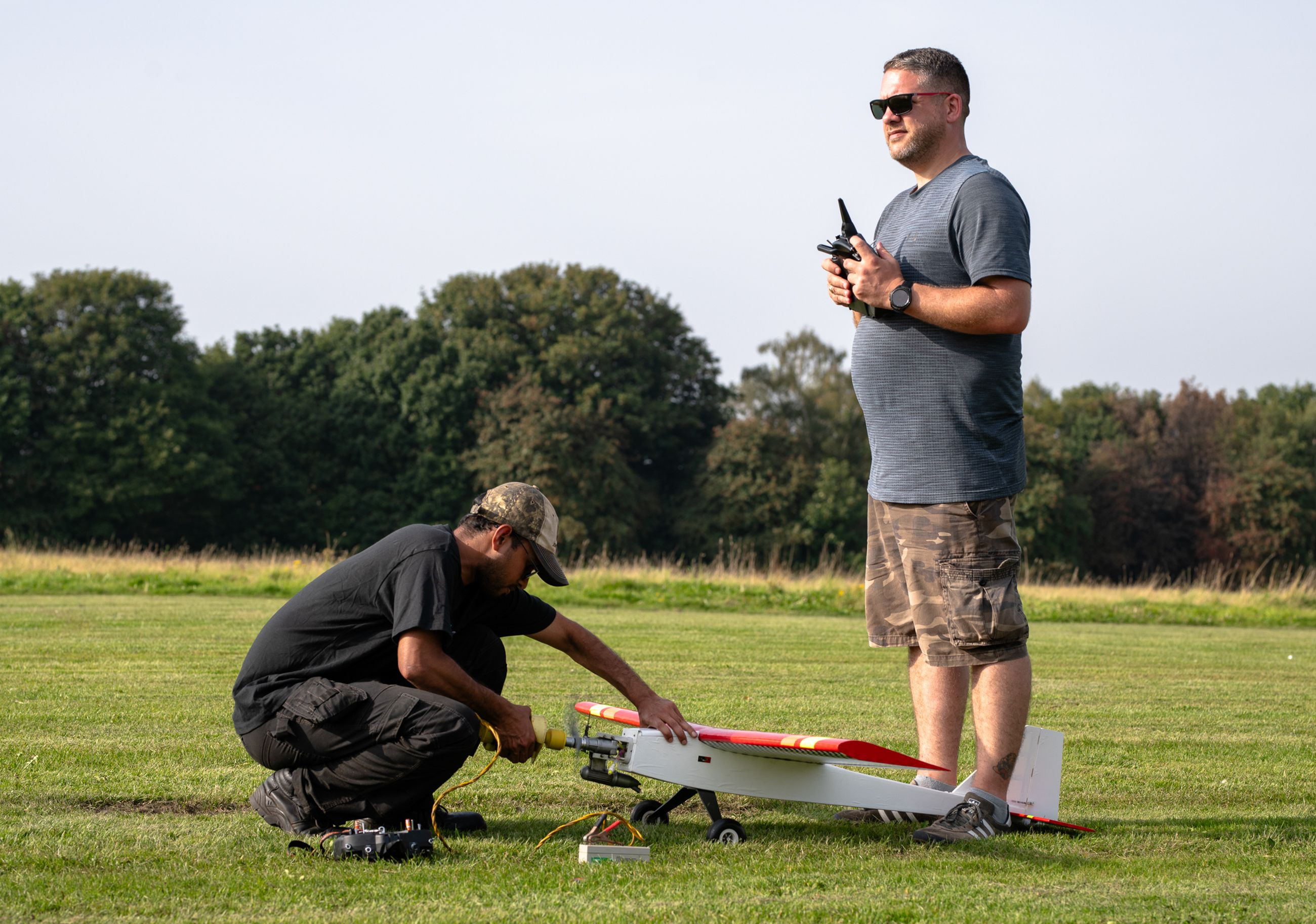 two people starting and RC plane engine