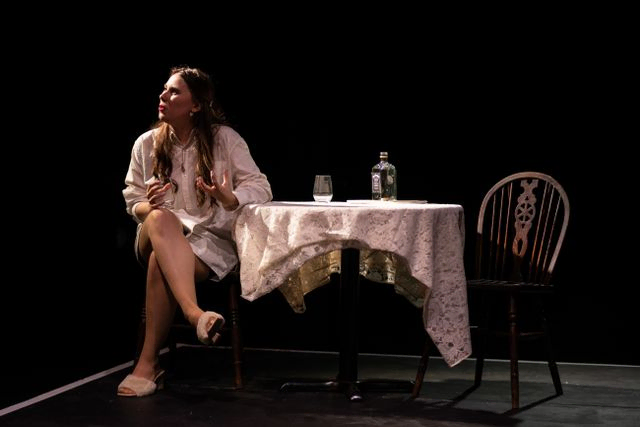 Women sitting at a table on stage drinking