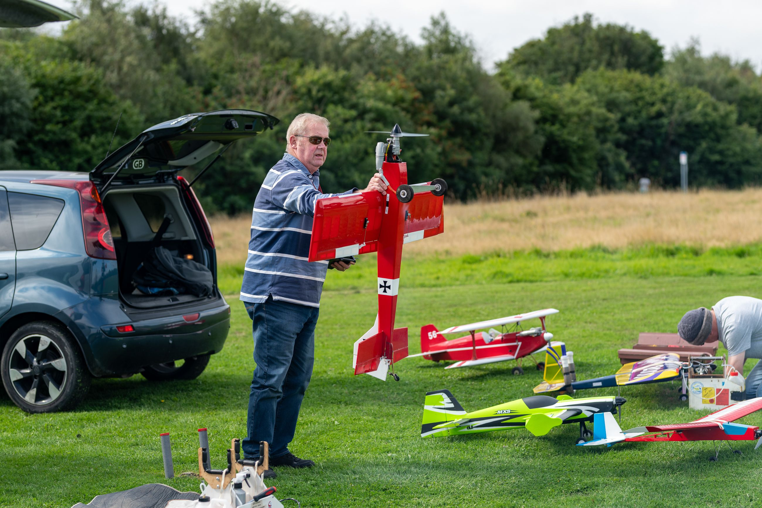 Man holding a red RC plane