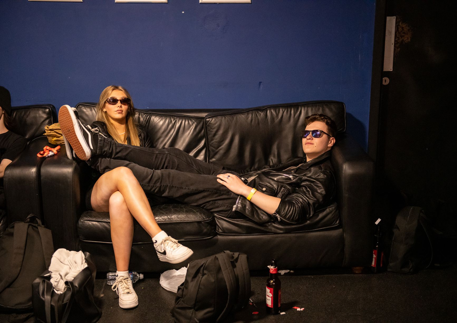 Man and women on sofa with black sun glasses on