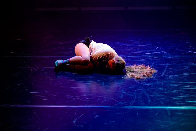 Female dancer in foetal position on stage