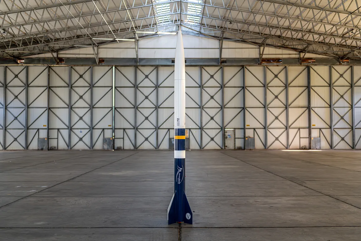 A rocket standing on its own in an aircraft hanger