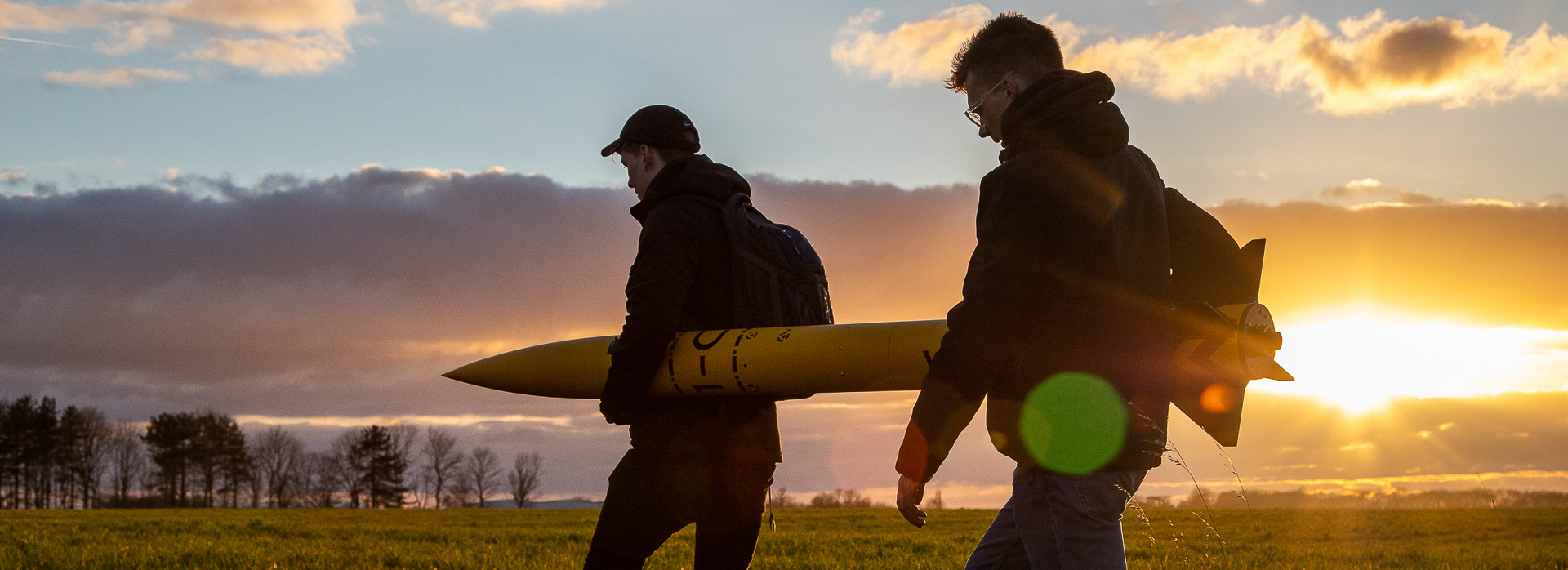 Two gentleman waking a rocket to the launch pad