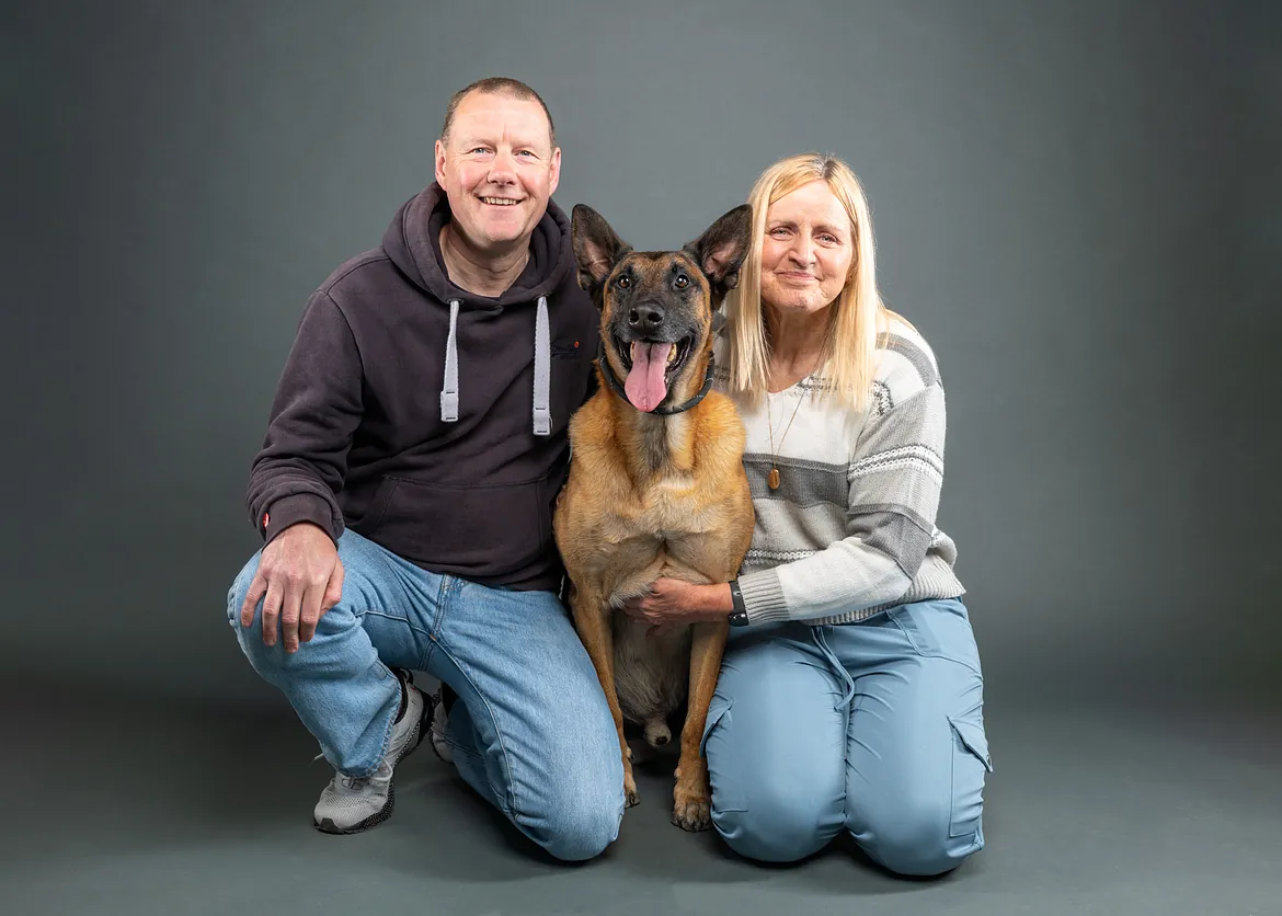 Dog with older couple posing for studio image