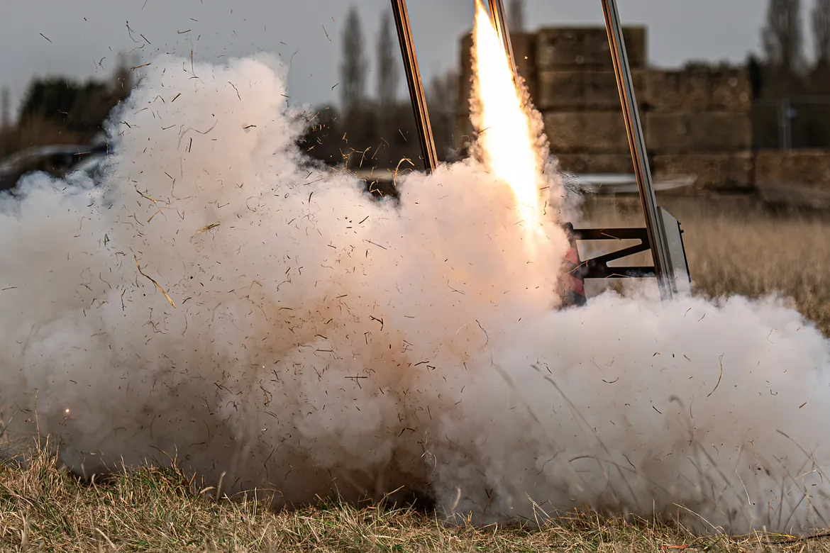 Rocket ignition kicking up lots of smoke and dust