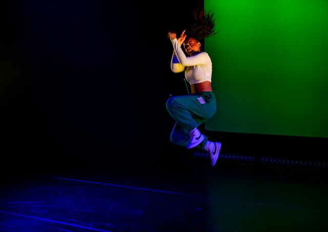 Jumping dancer in green light