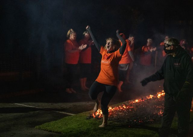 Woman cheering after walking across hot coals
