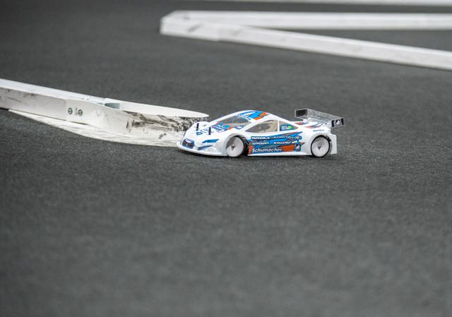 White and blue RC car going around the corner